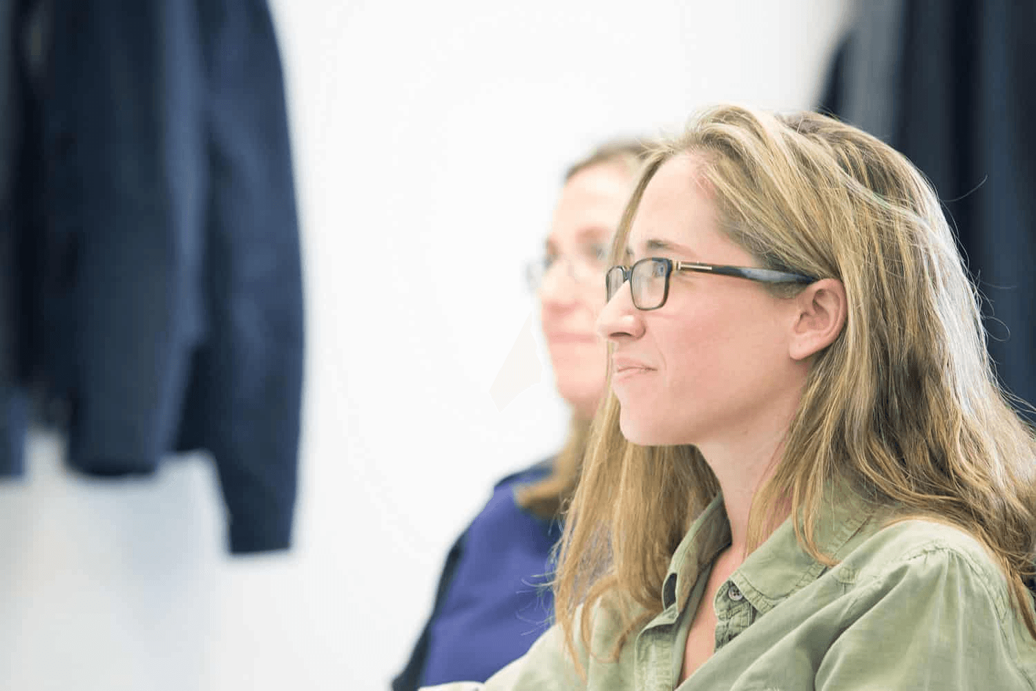 Blonde woman with glasses in a class