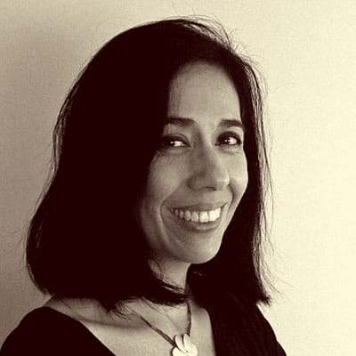 A black and white portrait of a smiling woman with dark hair.