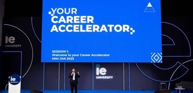 A speaker presenting at an event titled 'Your Career Accelerator' at IE University.
