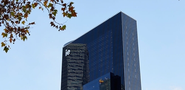A modern skyscraper with a sleek design against a clear blue sky.