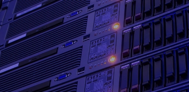 A row of server racks illuminated in blue and orange lights.