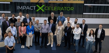 A group of people posing for a photo at the Impact Xcelerator event.