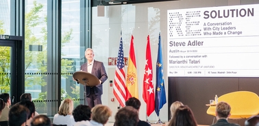 A public speaker addressing an audience during a conference on city leadership.