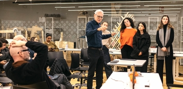 A group of people engaged in a discussion during a presentation in a classroom setting.