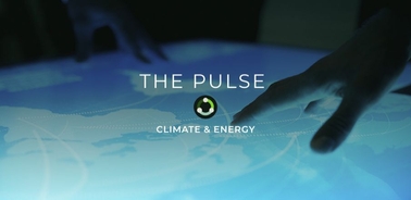 A close-up of hands interacting with a digital interface displaying a map related to climate and energy.