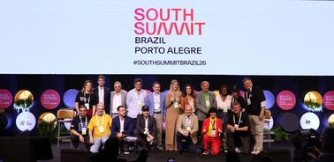 A group of people posing on stage during the South Summit event in Brazil.