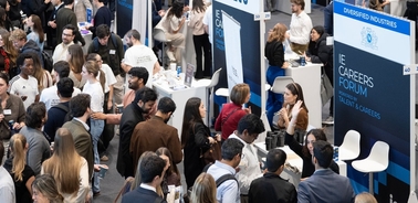 A bustling career fair with people engaging at booths and networking.