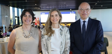 A group of three individuals posing together in a modern event setting.