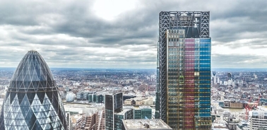 Aerial view of a city skyline showcasing modern skyscrapers under a cloudy sky.