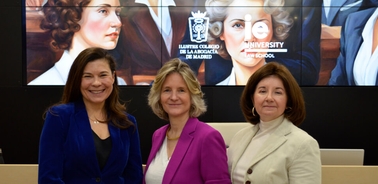 Three women standing in front of a banner featuring historical figures and institutional logos.