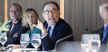 A group of business professionals sitting at a conference table engaged in a discussion.