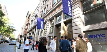 A group of people gathered outside a college building in New York City.