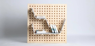 A modern bookshelf design made of a perforated panel with books arranged on stylish supports.