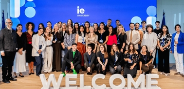 A diverse group of people gathered together in a welcoming environment at IE University.
