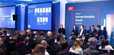 A business conference panel discussion with audience members attending.