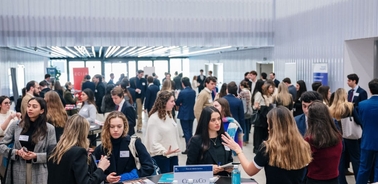 A group of people engaging in discussions at a professional event or conference.