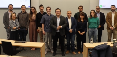 A group of twelve adults posing for a photo in a classroom setting.