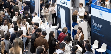 A busy career fair with attendees engaging at various booths.