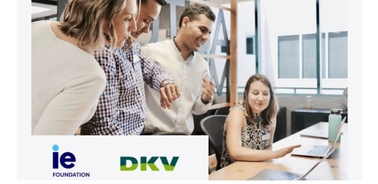 A group of professionals engaging in a discussion around a laptop in a modern office setting.