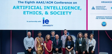A group of people standing together at a conference focused on artificial intelligence, ethics, and society.