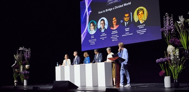 A panel discussion on bridging divided worlds with several speakers at a conference.