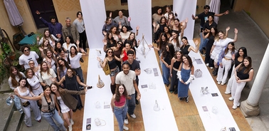 A large group of people gathering together, posing cheerfully in a creative space.
