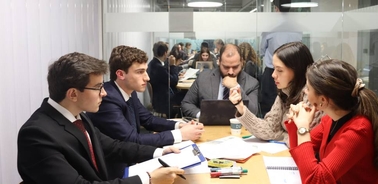 A group of professionals engaged in a discussion during a meeting.