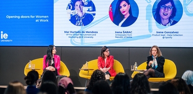 A panel discussion featuring three women in professional attire speaking about empowering women in the workplace.