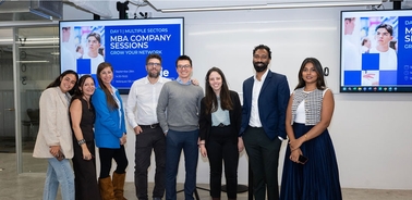 A group of professionals poses for a photo during MBA company sessions.