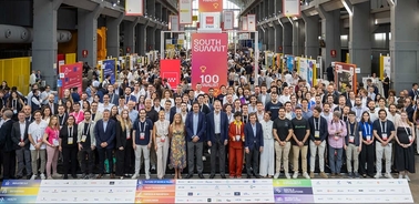 A large group of attendees poses together at an event, showcasing a vibrant atmosphere filled with networking opportunities.