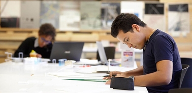 A focused individual working on a project at a modern workspace.
