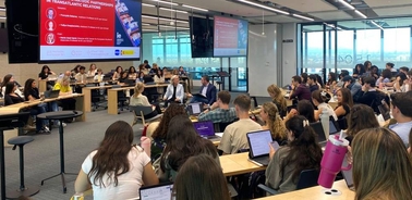 A large group of students seated in a classroom attending a presentation.