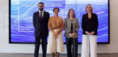 Four individuals standing in front of a presentation screen with text 'Presentación del Informe'.