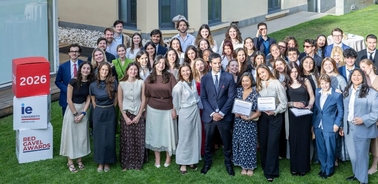 A large group of people posing together outdoors for a photo with awards in hand.