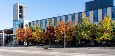 A modern building surrounded by vibrant autumn trees.