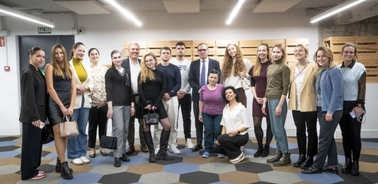 A group of people posing for a photo in an indoor, modern-looking setting.