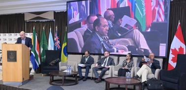 A conference setting with speakers and audience members engaging in a discussion.