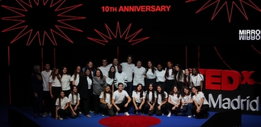 A group of people posing on a stage with the logo and text 'TEDxMadrid 10th Anniversary' displayed in the background.
