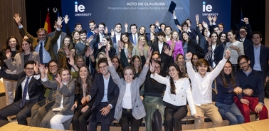 A group of joyful students in formal attire celebrating at a graduation ceremony.