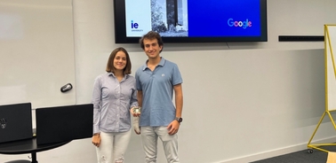 Two people standing in front of a presentation screen with Google and IE logos.