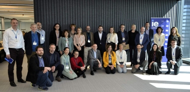 A group of business professionals posing for a photo in a modern office setting.