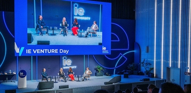 A panel discussion is taking place on stage at an event focused on entrepreneurship.