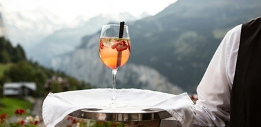 A refreshing cocktail served on a tray with mountains in the background.