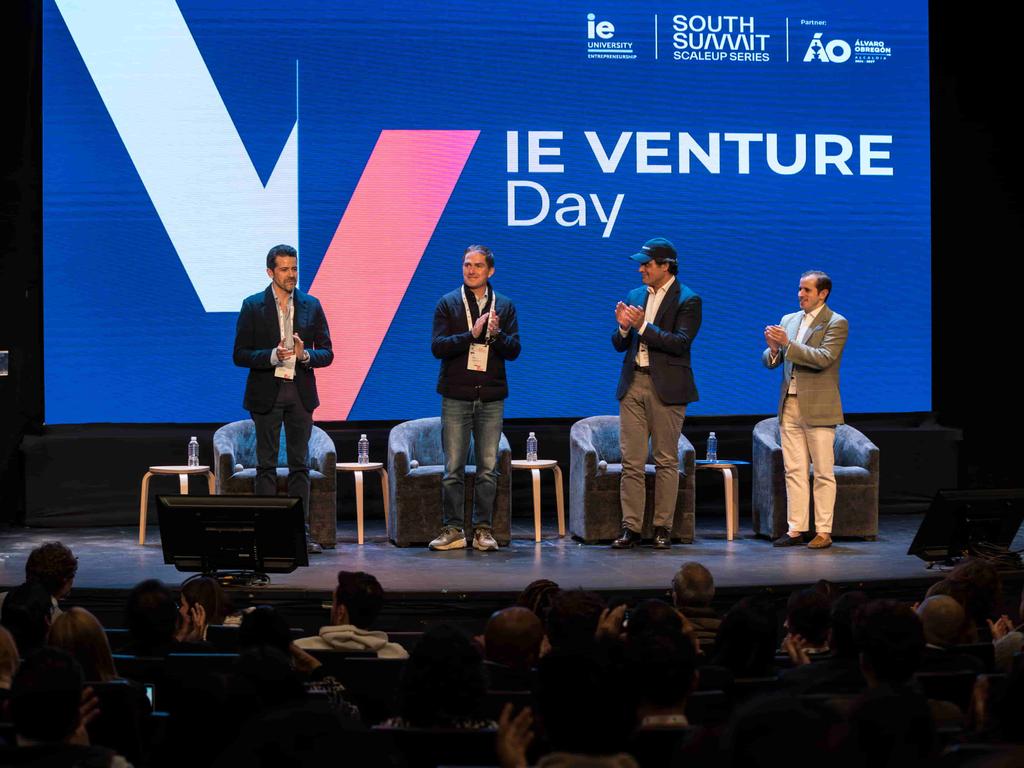 A group of speakers standing on stage at the IE Venture Day event.