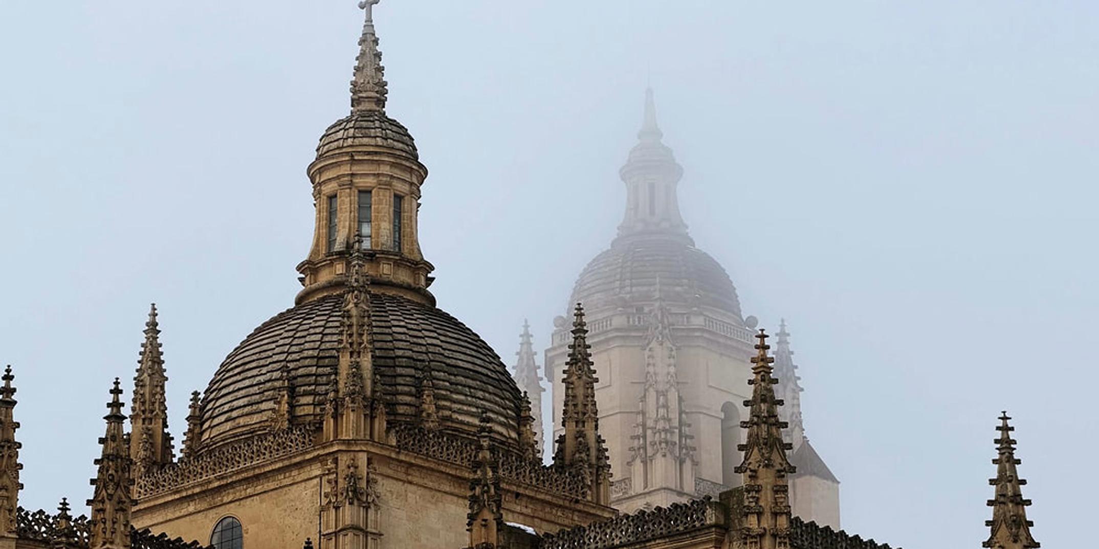 The image shows architectural domes partially obscured by fog.