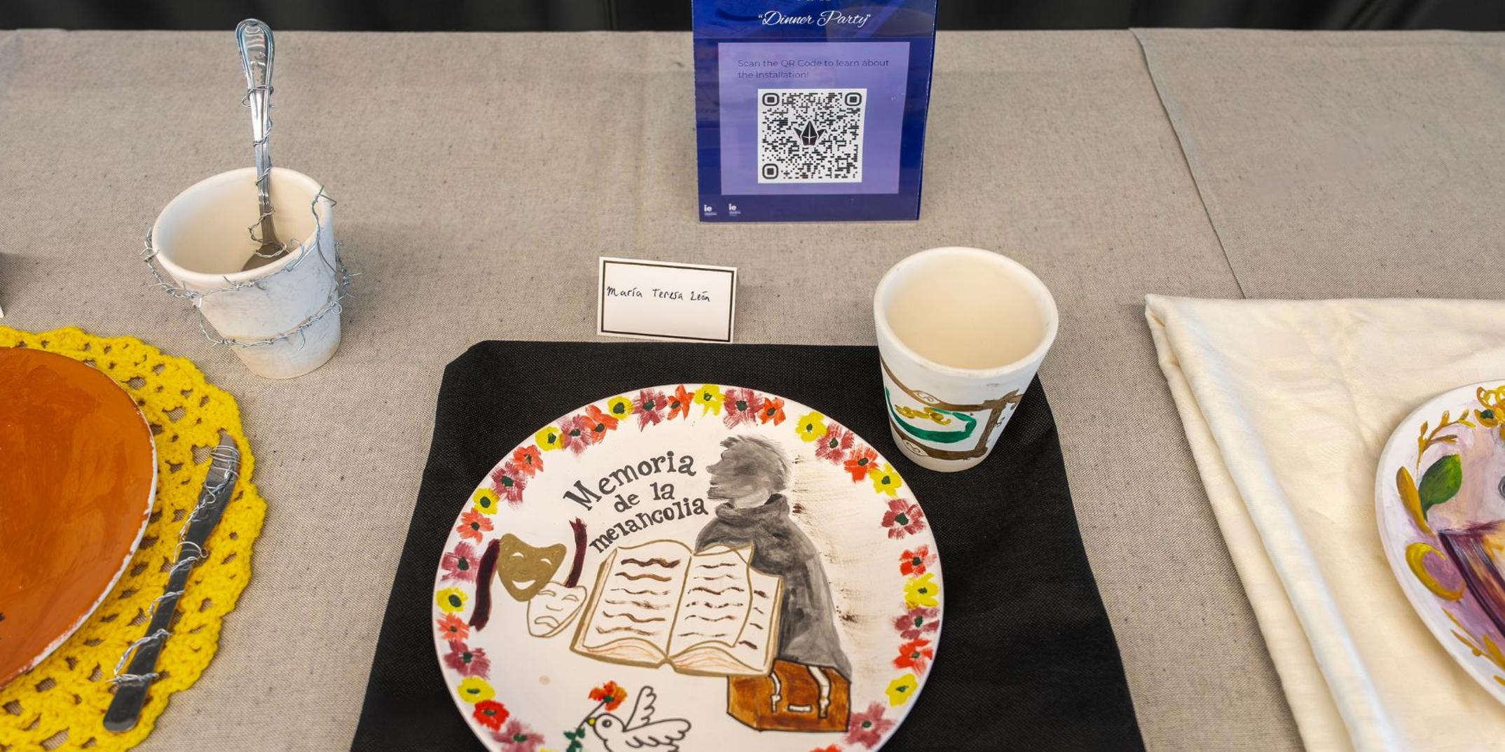 A decorative plate featuring a design of a girl reading a book, with accompanying items on display.