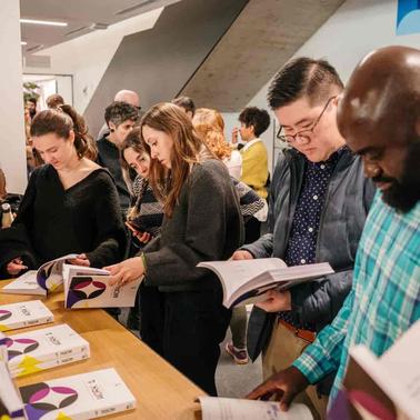 A group of people engaged in browsing through books at an event.