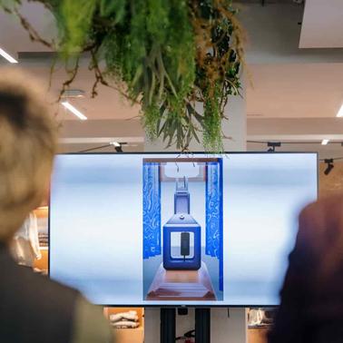 A modern display screen showcasing a high-tech object against a decorative backdrop.