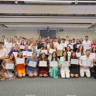 A group of students proudly displaying their certificates in a classroom setting.