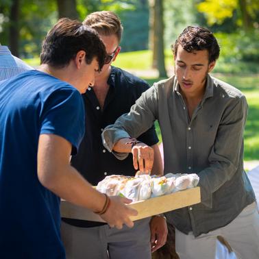 A group of people enjoying food in a park setting.